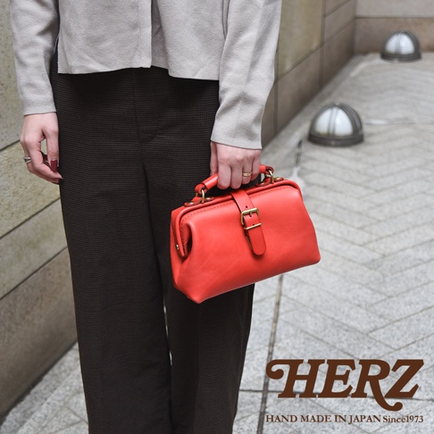 紅色皮革迷你軟皮杜勒斯包，配有金色搭扣和提把，由職人手工製作。