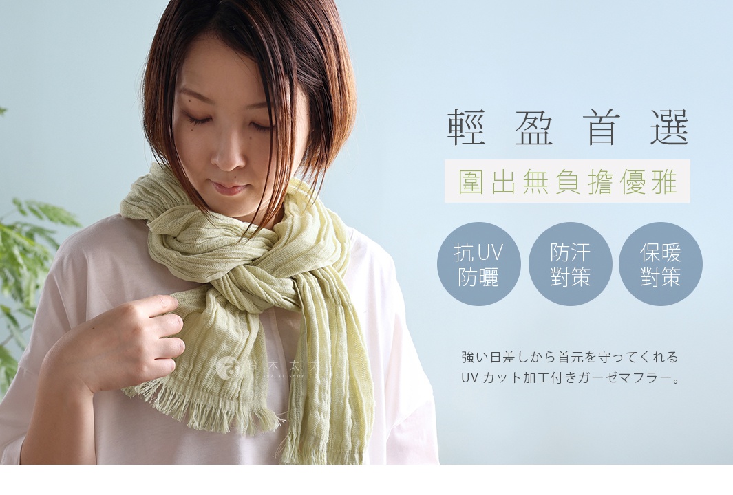 一位短髮女性模特兒配戴著淺綠色褶皺紋理純棉紗布圍巾，圍巾兩端帶有流蘇設計。圖片右側標題為輕盈首選，圍出無負擔優雅，並以三個圓形圖示列出產品具備抗UV防曬、防汗及保暖功能，下方日文說明該款紗布圍巾具有抗UV加工，可保護頸部免受強烈日曬。