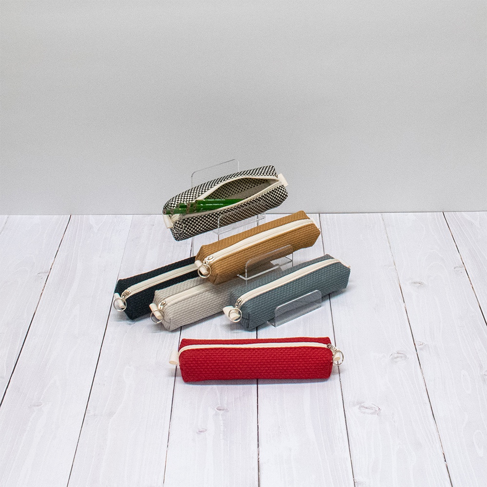 六款三河木綿刺子織筆袋，包括黑白格紋、卡其色、深藍色、淺灰色、藍綠色及紅色，皆為拉鍊開合設計，質感紋理清晰。