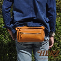 職人手作皮革兩用腰掛斜背包，採用棕褐色皮革製成，正面有一個拉鍊主袋和一個外部拉鍊小袋，可作為腰包或斜背包使用。