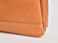 職人手作皮革橫式肩背托特包，採用淺棕色天然皮革，車縫線細緻，展現包款結構與皮革質感。