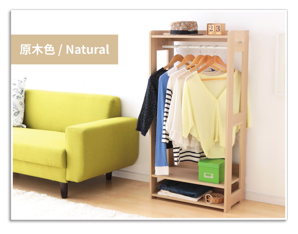 童心木製掛衣架 KWR-1260，原木色。衣架為淺木色，上方掛有五件不同顏色與款式的衣物，包含藍色、黑白條紋、白色荷葉邊上衣及淺黃色長袖上衣。下方層架擺放著一個綠色方形收納盒、摺疊的牛仔褲與腰帶。