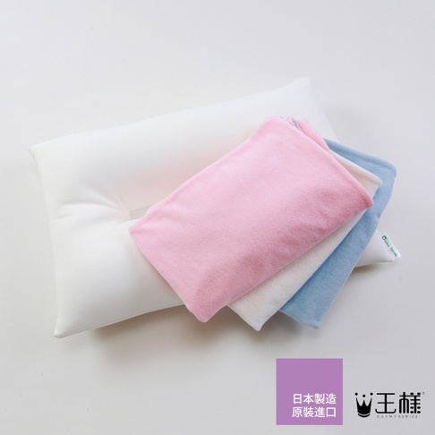 王樣の夢枕，一個白色枕頭疊放著粉紅色、白色和藍色三種顏色的枕套，材質看起來柔軟。