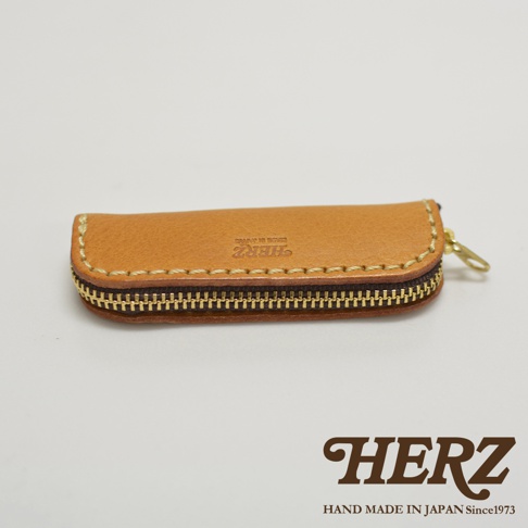 職人手作皮革印章收納袋 KZ-121，淺棕色牛皮材質，金屬拉鍊，縫線精緻，袋身壓印有品牌標誌。