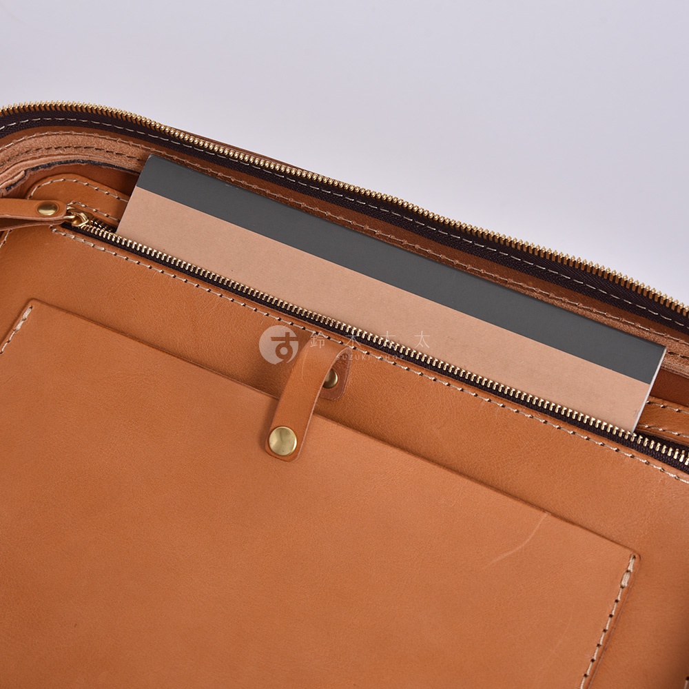 職人手作皮革兩用商務後背包 R-33，展示其內部結構。淺棕色皮革材質，拉鍊開合，內有文件隔層和筆記本。