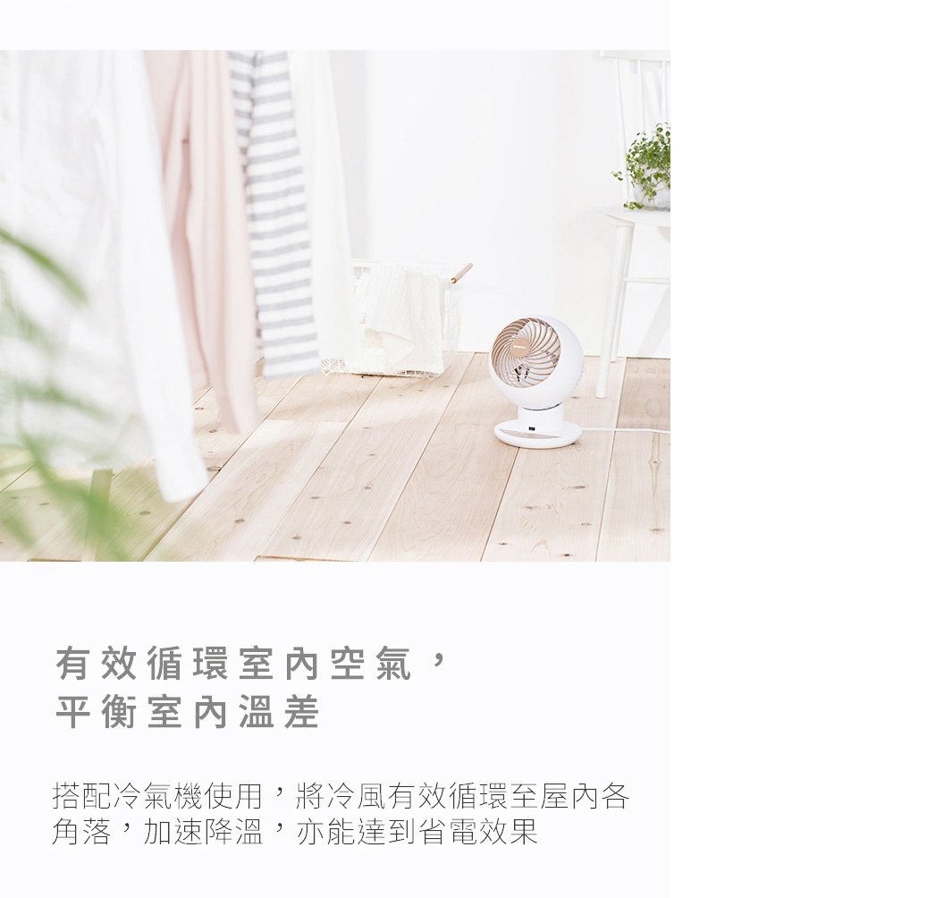 白色圓形空氣循環扇，帶有木紋風格底座，放置於淺色木質地板上，背景有衣物和綠植。