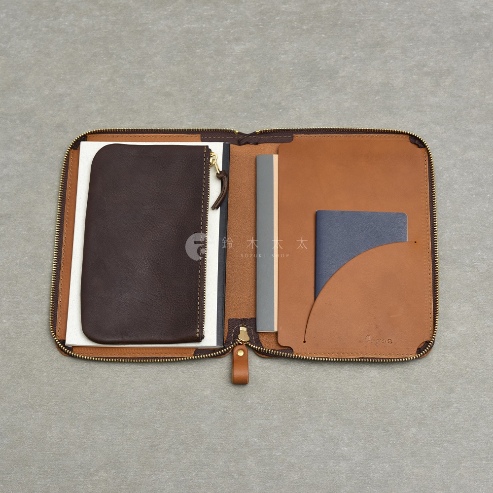 一個敞開的棕褐色皮革收納包，裡面裝有筆記本、文件夾和拉鍊袋。