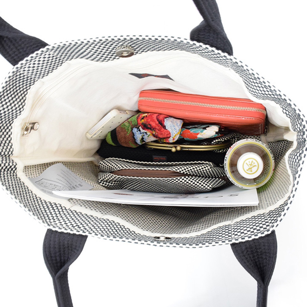 三河木綿刺子織OBI托特包，黑白棋盤格紋，內含橘紅色皮夾、手機、零錢包、化妝包及一瓶飲品。