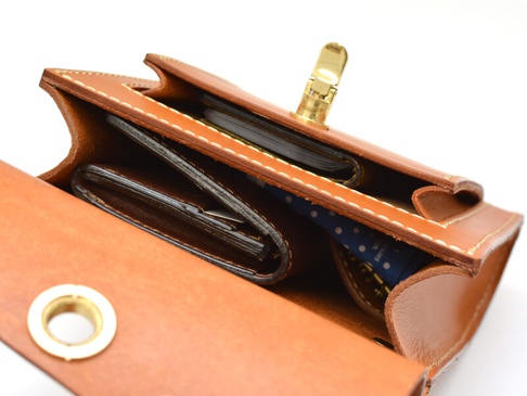 職人手作皮革厚實單肩包（CP-61），焦糖棕色皮革，內部可見多個卡片夾、一個錢包及藍底白點的物品。包款使用精緻縫線，並配有金色金屬鎖扣。