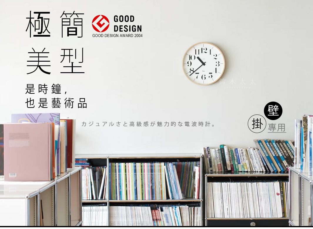 RIKI Lightness時鐘(M)，圓形木質錶框，白色錶盤，黑色阿拉伯數字時標，黑色指針，掛於牆面，下方為書櫃擺放書籍。