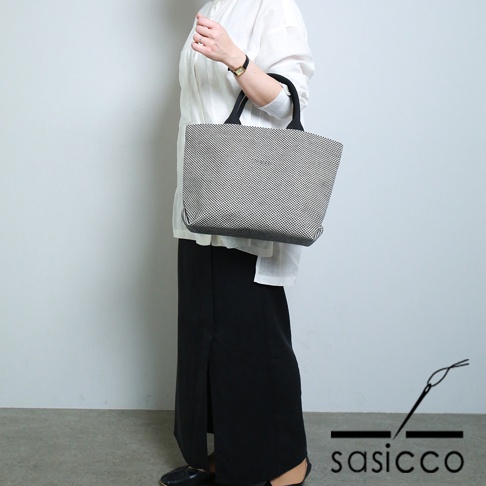 三河木綿刺子織經典托特包，黑白棋盤格紋，配有黑色皮革提把，包身側面為深灰色。