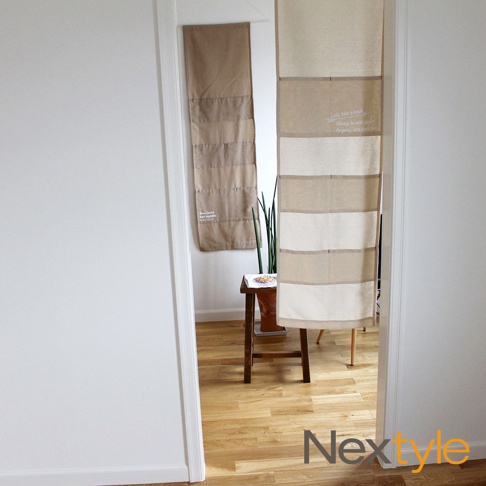 出雲雅逸口袋門簾，米色和淺棕色布料拼接，共七層口袋設計，其中一層印有白色英文文字，質感樸實。