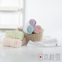 一籃五條捲起的今治超長棉毛巾，顏色包含淺紫、淺藍、粉紅。籃子旁另有三條捲起的毛巾，顏色為淺綠、淺粉紅和淺棕色。右側為一條展開的白色毛巾。