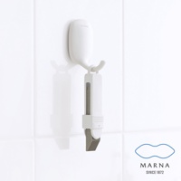 白色萬用去污橡皮擦，掛於白色掛鉤上，橡皮擦主體為白色塑膠，內嵌灰色磨砂材質，末端為斜角設計。