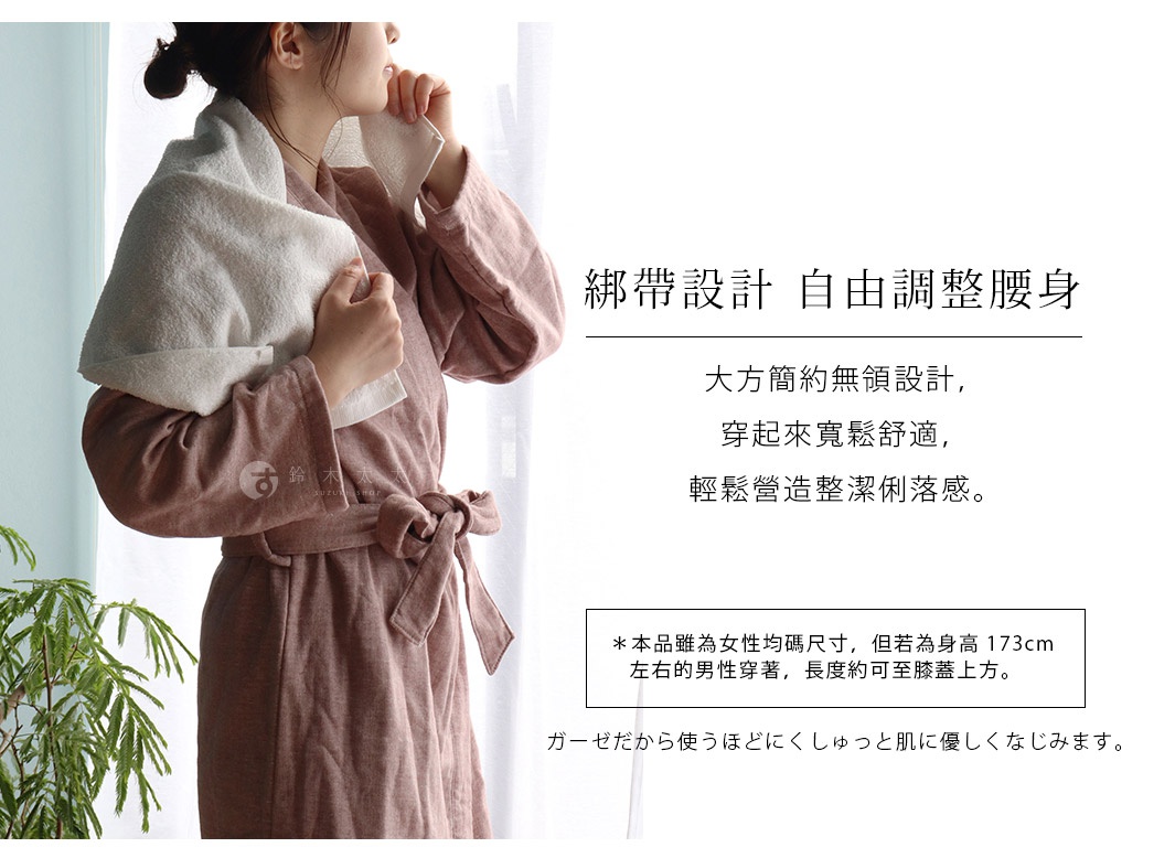 一位女性身穿粉色長袖紗質浴袍，腰間繫著同色系腰帶，頭部搭著一條白色吸水髮巾，浴袍材質輕柔，顯得舒適自在。