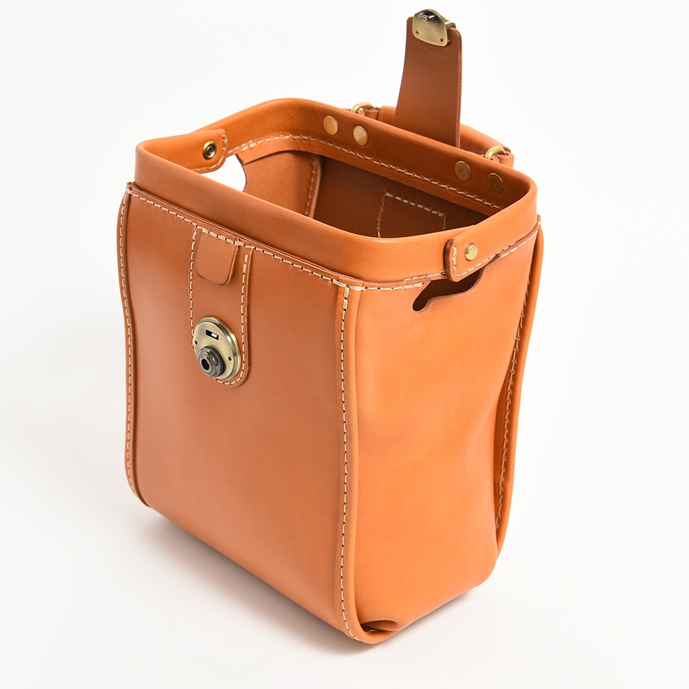 棕色皮革迷你後背醫生包，採用車縫線裝飾，配有復古金屬鎖扣和磁吸開合。