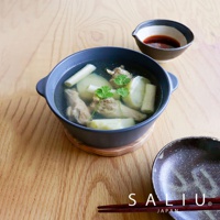 深灰色陶製圓鍋盛著雞湯，鍋內有雞肉塊、冬瓜塊及香菜，鍋旁有一小碟醬料，鍋下墊著木質鍋墊，上方放著一雙筷子。