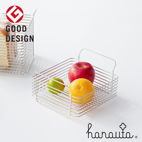 一個不鏽鋼淺型收納籃，裝有紅蘋果、綠檸檬和黃柳橙。另一個籃子裡裝有切片麵包。