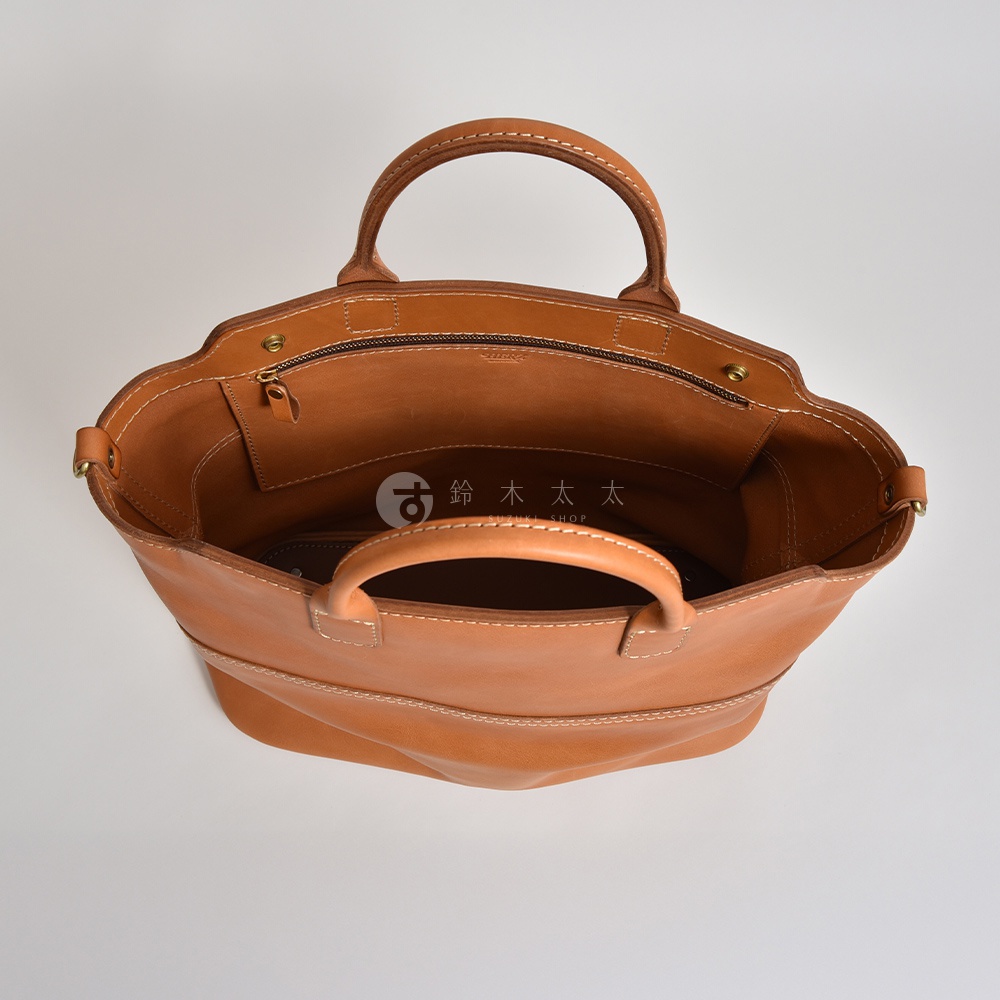 職人手作皮革托特包，淺棕色，展示包內空間，有拉鍊開合及手提把。