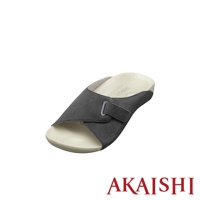 一只深灰色麂皮材質、可調節魔術貼帶的室內拖鞋，鞋底為米白色，鞋墊上有品牌標誌。