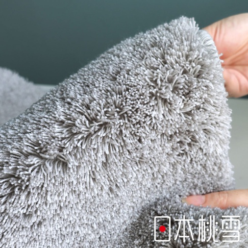 毛茸茸的灰色浴墊，角落有「日本桃雪」標誌