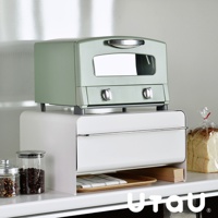 白色抽屜式收納櫃，上層放置薄荷綠色烤箱，櫃體前方有銀色金屬把手，下方抽屜內有格子布墊與木盤。