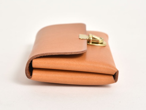 淺棕色皮革製作的職人手作小卡片收納夾，附有金色金屬鎖扣，整體造型簡潔，皮革紋理清晰可見。