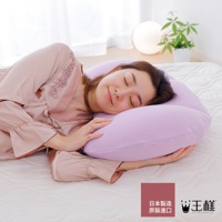 一位女子側臥，頭枕在薰衣草色枕套的舒肩枕上，枕頭形狀符合人體工學，提供頸部和肩部支撐。