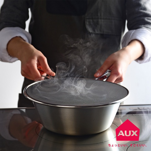 一個 24 公分的leye 低反光黑色透視防噴濾網，覆蓋在一個金屬鍋上，鍋中正冒出蒸汽。濾網的邊緣是金屬色，而濾網本身是細密的黑色網狀結構。