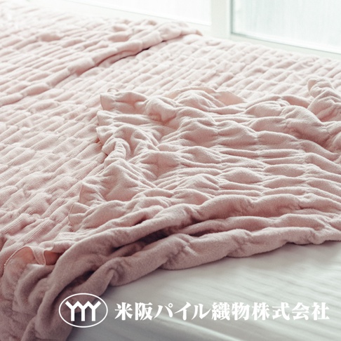 粉紅色輕暖柔蓬抗摩四季毯，表面有立體紋路，質地柔軟，鋪蓋在床上。