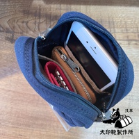 石洗帆布斜背手機包，深藍色，包內裝有白色手機、棕色零錢包和紅色鑰匙圈。