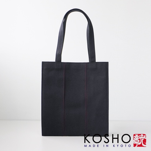 深藍色棉帆布扇形托特包，正面有三條紅色縫線裝飾，配有黑色織帶提把。