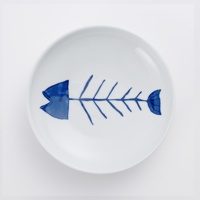 白色陶瓷小碟，中央繪有藍色簡約魚骨圖案，魚頭部分為實心藍色，魚身骨架及尾鰭為藍色線條。