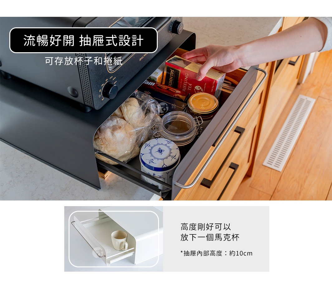 一個附有手柄的黑色抽屜式收納櫃，裡面裝有麵包、茶葉罐和罐子，抽屜上方有一台微波爐。