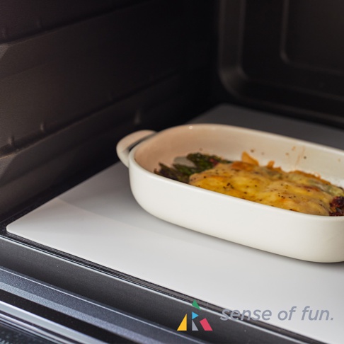 耐高溫微波爐防污保護墊上，擺放著裝有起司焗烤鮮蝦的烤盤。