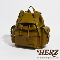 職人手作皮革復古風旅行後背包，橄欖綠色，搭配金色釦環，主體為皮革材質，設有頂部提把、束繩開口、翻蓋、側面口袋及前方拉鍊口袋，設計簡約實用。