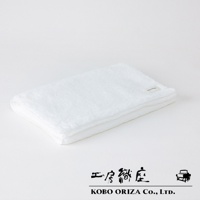 一張摺疊的白色匹馬棉毛巾，毛巾質地柔軟，邊緣有一個小標籤。