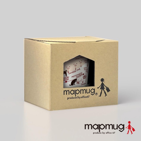瓦楞紙盒內露出mapmug手繪地圖馬克杯，杯身白色，印有紅色線條的橫濱散步地圖，包含「yamashita park」、「Motomachi-Chukagai」等字樣，以及可愛的黑貓剪影和日式建築插畫。盒子上印有mapmug品牌標誌及小女孩提袋的剪影。