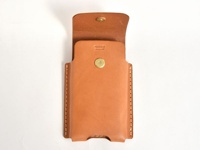 職人手作淺棕色皮革三用手機收納包，正面有金色金屬按扣，翻蓋處也有一個金色金屬按扣。包體側面有明顯的縫線。