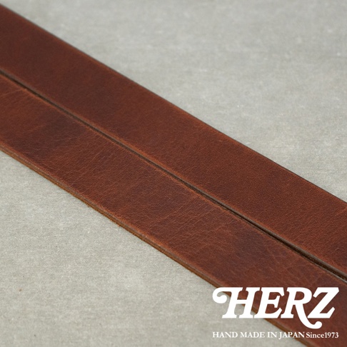 日本HERZ皮革皮帶，近拍皮革紋理細節，品牌標誌HERZ與手工製造字樣。