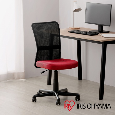 一張紅色網布主管椅，具有黑色椅背、黑色五爪椅腳和滾輪，擺放在淺木紋地板上，後方為木紋桌面，桌上有電腦螢幕、鍵盤、檯燈，以及右下角的IRIS OHYAMA 商標。