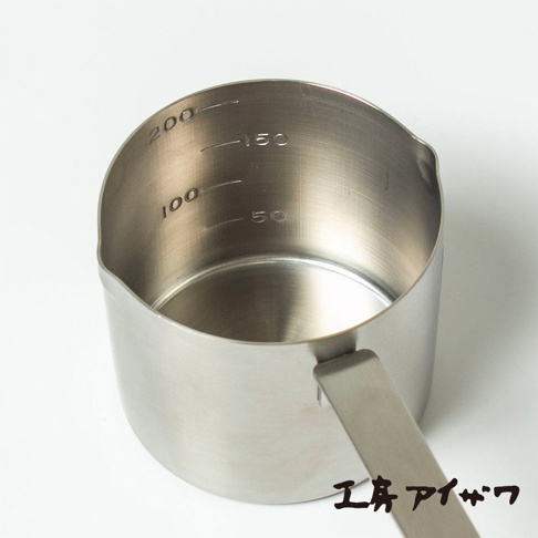 一只銀色不鏽鋼雙口長柄計量杯，杯壁刻有 50、100、150、200 的刻度線。