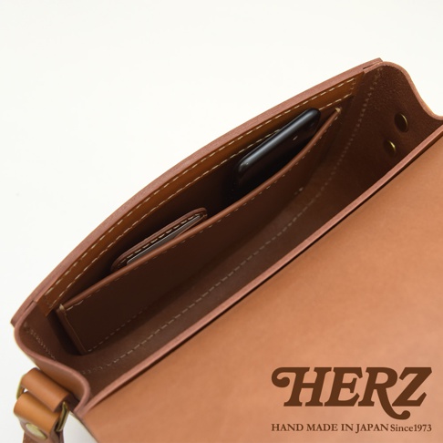 職人手作皮革經典馬鞍包 CK-7 M，展示內部結構，包含手機夾層及卡片槽，皮革為棕褐色，車縫線為白色。