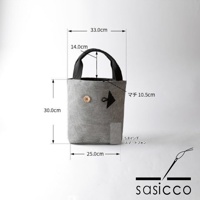 灰色刺子織布料製成的直式托特包，綴有木質鈕扣和黑色箭頭標誌，尺寸標示為高30公分、寬25公分、厚10.5公分，提把高14公分。