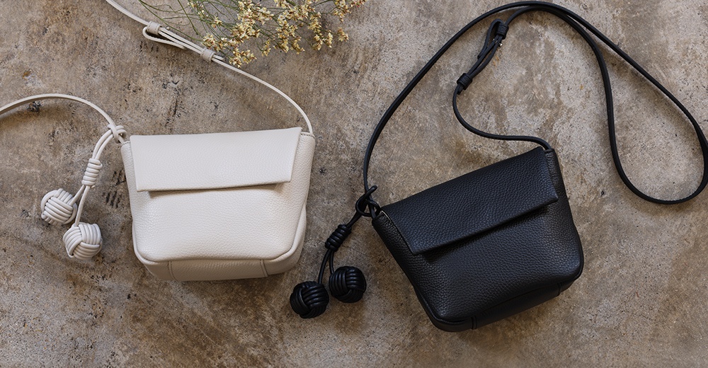 itten-itten Neru 義大利皮革點結吊飾迷你單肩包，共有黑白兩色，以溫潤的義大利皮革製成，並飾有可愛的點結吊飾。