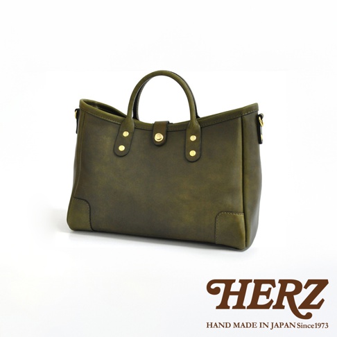 一咖橄欖綠皮革手提托特包，具有圓潤的提把、金屬釦飾及簡潔的線條設計。