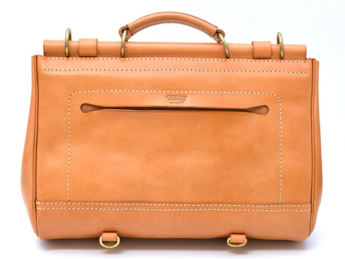 職人手作瓦風三用側背包，採用原色牛皮材質，配有黃銅色五金配件。包身正面有品牌標誌、拉鍊暗袋及縫線裝飾，底部兩側設有D型環，可連接肩帶。