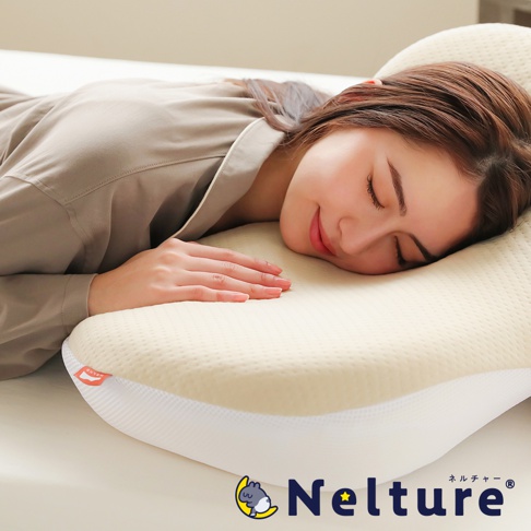 一位女性側臥在乳白色、帶有細緻紋路的 Q 彈棉花糖枕上，枕頭輪廓符合人體工學，邊緣飾有白色網眼材質，左側有橘色品牌標籤，右下角為「Nelture」品牌標誌。