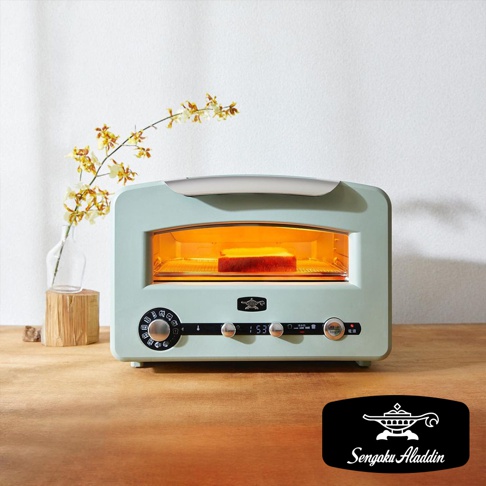 一台淺藍色的阿拉丁烤箱，內有吐司正在烘烤，烤箱下方有操控面板和品牌標誌