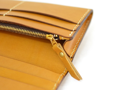 淺棕色皮革長夾，特寫拉鍊細節與內部卡槽。